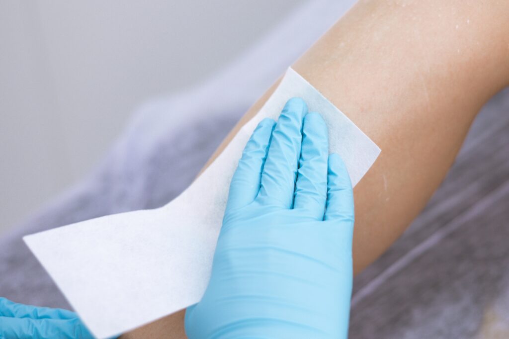 female legs hair removal with wax in beauty salon